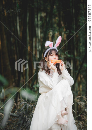 在森林裡穿著白色連衣裙的兔子形式的女人 95567545