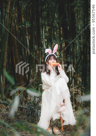 在森林裡穿著白色連衣裙的兔子形式的女人 95567546
