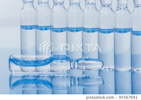 Glass medical ampoule vial for injection. Medicine is liquid sodium chloride with of aqueous solution in ampulla. Close up. Bottles ampule multicolor. Glass medical ampoule vial for injection. Medicine is liquid sodium chloride with of aqueous solution in ampulla. Close up. Bottles ampule multicolor. 95567691