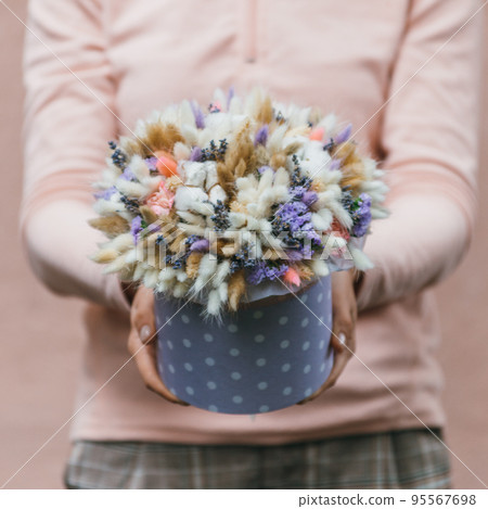 Colorful bouquet of different dried flowers deadwood flowers in the hands of florist woman. Rustic flower background. Craft bouquet of flowers. 95567698