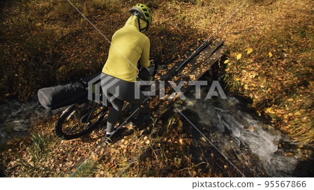 The woman travel on mixed terrain cycle touring with bikepacking. The traveler journey with bicycle bags. Sport tourism bikepacking. The woman travel on mixed terrain cycle touring with bikepacking. The traveler journey with bicycle bags. Sport tourism bikepacking. 95567866