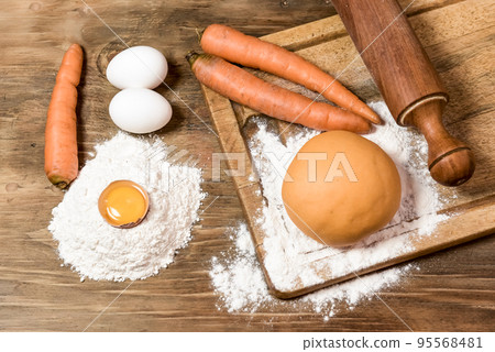 Orange carrot noodle dough bun, with ingredients on the table. Orange carrot noodle dough bun, with ingredients on the table. 95568481