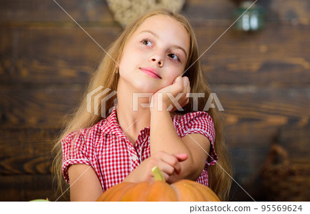 Harvest festival concept. Girl kid at farm market with organic vegetables. Grow your own organic food. Kid farmer with harvest wooden background. Child little girl enjoy farm life. Organic gardening 95569624