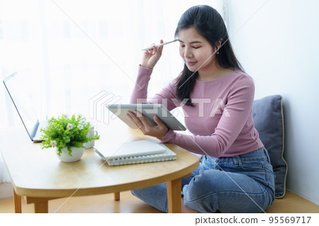 Portrait of a beautiful Asian teenage girl using a tablet computer. Portrait of a beautiful Asian teenage girl using a tablet computer. 95569717