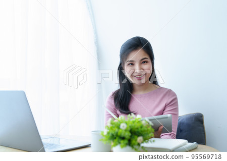 Portrait of a beautiful Asian teenage girl using a tablet computer. Portrait of a beautiful Asian teenage girl using a tablet computer. 95569718