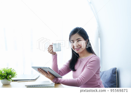 Portrait of a beautiful Asian teenage girl using a tablet computer. Portrait of a beautiful Asian teenage girl using a tablet computer. 95569871