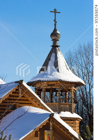 View of a snow-covered wooden Russian Orthodox Church, made in a traditional style, winter landscape View of a snow-covered wooden Russian Orthodox Church, made in a traditional style, winter landscape 95569874