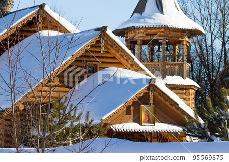 View of a snow-covered wooden Russian Orthodox Church, made in a traditional style, winter landscape View of a snow-covered wooden Russian Orthodox Church, made in a traditional style, winter landscape 95569875