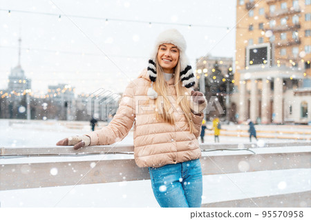 Beautiful lovely middle-aged girl blonde hair warm winter jackets knitted glove stands ice rink background Town Square. Christmas mood lifestyle Beautiful lovely middle-aged girl blonde hair warm winter jackets knitted glove stands ice rink background Town Square. Christmas mood lifestyle 95570958