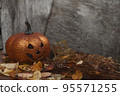 Glittering Halloween pumpkin in autumn leaves on wooden background. Seasonal compostion 95571255