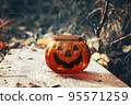 Halloween pumpkin candlestick in autumn forest. Laughing Candlelight 95571259