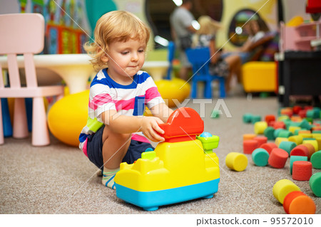 Child playing with colorful toys at the learning center or in kindergarten 95572010