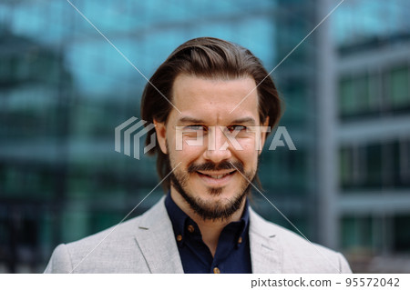 Serious adult businessman in formal wear posing towards modern office building 95572042