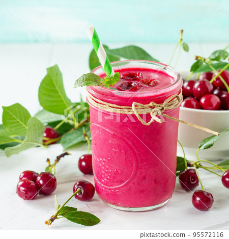 Cherry milkshake or smoothie on a white wooden background. Healthy juicy vitamin drink diet or vegan food concept. Copy space. 95572116