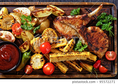 bbq tomahawk pork chop with corn and potatoes bbq tomahawk pork chop with corn and potatoes 95572271