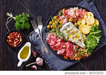 savory baked brie with crackers, salami, nuts, ham savory baked brie with crackers, salami, nuts, ham 95572272
