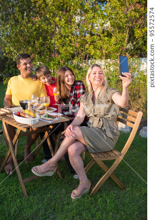 Joyful family taking selfie at BBQ party 95572574