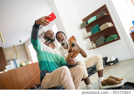 Portrait of African gay men taking selfie with new stylish shoes Portrait of African gay men taking selfie with new stylish shoes 95572803