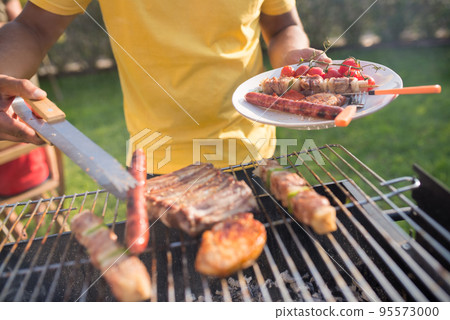 Close-up of man cooking meat and vegetables Close-up of man cooking meat and vegetables 95573000