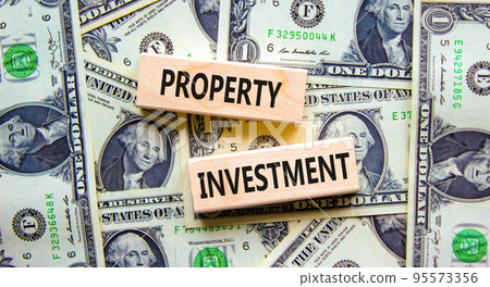 Property investment symbol. Concept words Property investment on wooden blocks on a beautiful background from dollar bills. Business Property investment concept. Copy space. Property investment symbol. Concept words Property investment on wooden blocks on a beautiful background from dollar bills. Business Property investment concept. Copy space. 95573356