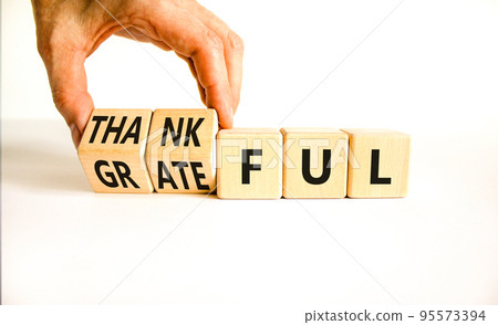 Thankful and grateful symbol. Concept words Thankful and Grateful on wooden cubes. Businessman hand. Beautiful white table white background. Business thankful and grateful concept. Copy space. Thankful and grateful symbol. Concept words Thankful and Grateful on wooden cubes. Businessman hand. Beautiful white table white background. Business thankful and grateful concept. Copy space. 95573394