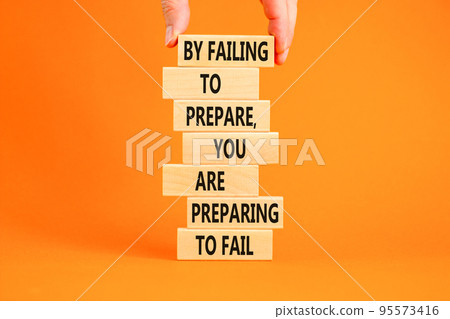 Preparing symbol. Concept words By failing to prepare you are preparing to fail on wooden blocks on a beautiful orange background. Businessman hand. Business motivational and preparing concept. 95573416