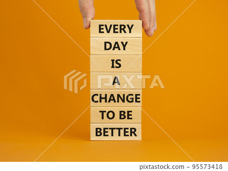 Change to be better symbol. Wooden blocks with words Every day is a change to be better. Beautiful orange background, copy space. Businessman hand. Business, motivational change to be better concept. 95573418