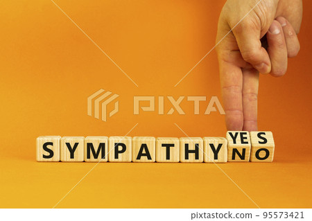 Sympathy yes or no symbol. Concept words Sympathy yes or Sympathy no on wooden cubes. Psychologist hand. Beautiful orange table orange background. Business sympathy yes or no concept. Copy space. 95573421
