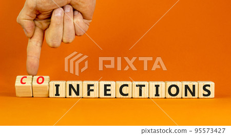 Coinfections or infections symbol. Concept words Coinfections and Infections on wooden cubes. Doctor hand. Beautiful orange background. Medical coinfections or infections concept. Copy space. Coinfections or infections symbol. Concept words Coinfections and Infections on wooden cubes. Doctor hand. Beautiful orange background. Medical coinfections or infections concept. Copy space. 95573427