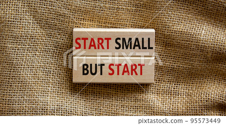 Start small but start symbol. Concept words 'Start small but start' on wooden blocks on a beautiful canvas background. Business, motivational concept. 95573449