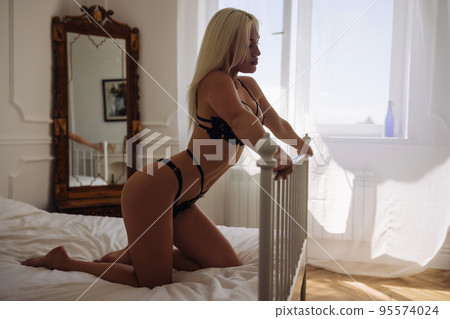 Extremely beautiful and young adult caucasian woman wearing lingerie in a boudoir bedroom setting in various poses. Extremely beautiful and young adult caucasian woman wearing lingerie in a boudoir bedroom setting in various poses. 95574024