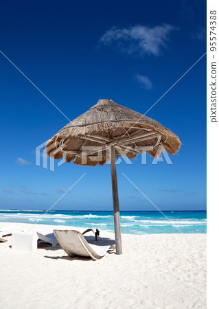 Sun umbrella ans sunbed on white sandy beach with turquoise ocean water. Caribbean sea travel destination. Bounty and pristine nature for vacation 95574388