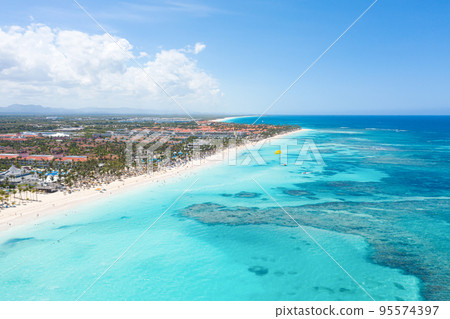 Bounty and pristine sandy shore with coconut palm trees, caribbean sea washes tropical coast. Arenda Gorda beach. Dominican Republic. Aerial view 95574397