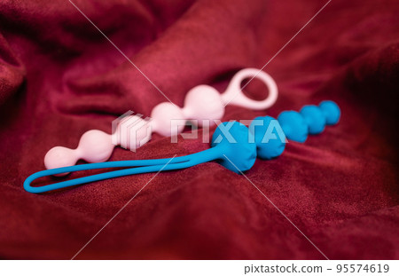 Woman holding anal balls in bed close-up. 95574619