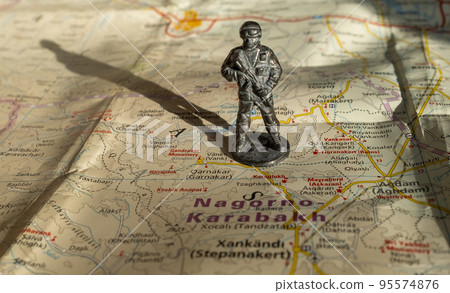A figurine of an armed soldier on the map of Nagorno-Karabakh. 95574876