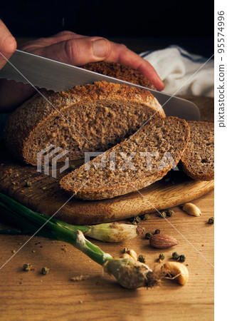 men's hands cut bread with a knife men's hands cut bread with a knife 95574996