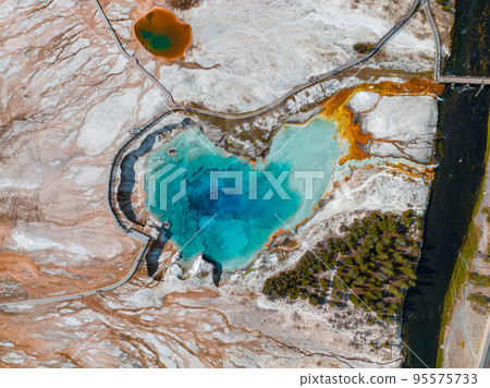 Castle Geyser erupts with hot water and steam with pools of thermophilic bacteria and it's a cone geyser in the Upper Geyser Basin of Yellowstone National Park, Wyoming, United States. 95575733