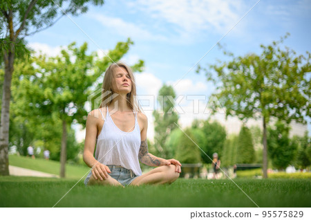 Girl practice yoga meditation outdoor in park 95575829