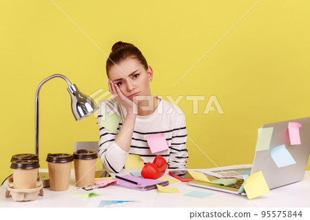 Bored woman office employee covered with sticky sitting at workplace leaning head on hands, lonely disappointed female tired of wimp work. notes Indoor studio studio shot isolated on yellow background Bored woman office employee covered with sticky sitting at workplace leaning head on hands, lonely disappointed female tired of wimp work. notes Indoor studio studio shot isolated on yellow background 95575844