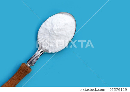 Baking soda on blue background. Baking soda on blue background. 95576129