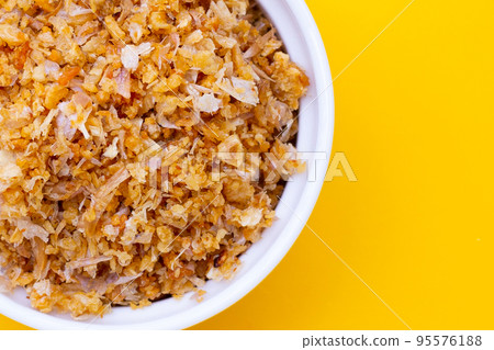 Dried chopped garlic on yellow background. Dried chopped garlic on yellow background. 95576188