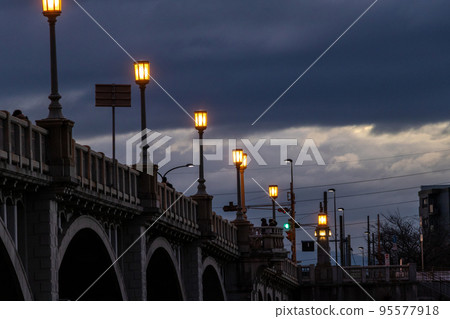 Streetlights shining on the bridge in the dark before dawn 95577918