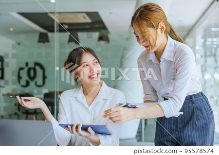 Negotiation, Analysis, Discussion: Portrait of an Asian woman economist and marketer pointing to a financial data sheet to plan investments to prevent risks and losses for the company. Negotiation, Analysis, Discussion: Portrait of an Asian woman economist and marketer pointing to a financial data sheet to plan investments to prevent risks and losses for the company. 95578574