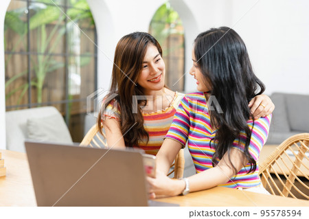 lgbtq, lgbt concept, homosexuality, portrait of two asian women posing happy together and loving each other while playing computer laptop. 95578594
