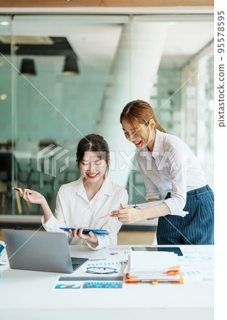 Negotiation, Analysis, Discussion: Portrait of an Asian woman economist and marketer pointing to a financial data sheet to plan investments to prevent risks and losses for the company. 95578595