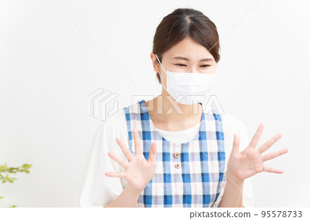 A nursery teacher wearing a mask and waving with a smile 95578733