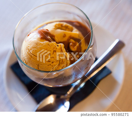 Tasty cold chocolate ice cream served with hot chocolate cream 95580271