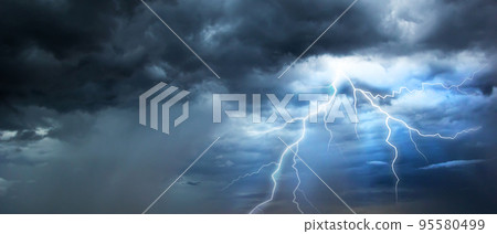 The dark sky with heavy clouds converging and a violent storm before the rain.Bad or moody weather sky. 95580499