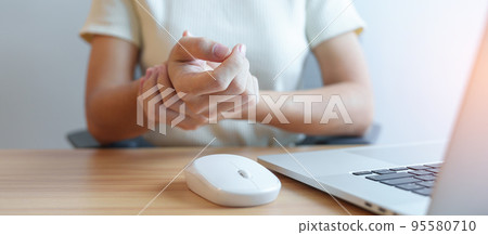 Woman having wrist pain when using mouse during working long time on workplace. De Quervain s tenosynovitis, ergonomic, Carpal Tunnel Syndrome or Office syndrome concept Woman having wrist pain when using mouse during working long time on workplace. De Quervain s tenosynovitis, ergonomic, Carpal Tunnel Syndrome or Office syndrome concept 95580710