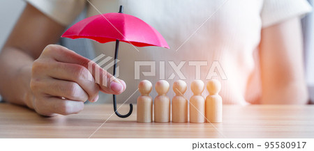 hand holding red umbrella and cover wood men from crowd of employees. People, Business, Human resource management, Life Insurance, Teamwork and leadership Concepts hand holding red umbrella and cover wood men from crowd of employees. People, Business, Human resource management, Life Insurance, Teamwork and leadership Concepts 95580917